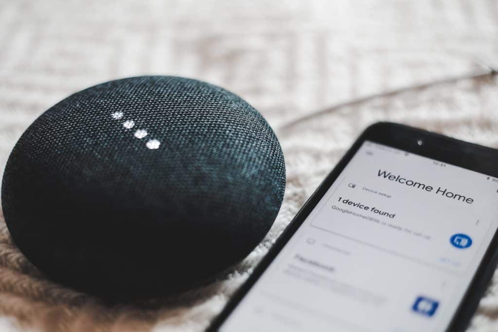 fusain allumé Google Home Mini et smartphone